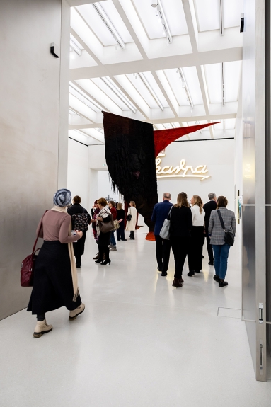 Zdjęcie przedstawiające wejście do galerii Muzeum. W tle monumentalny abakan czyli tkana rzeźba Magdaleny Abakanowicz zwisająca z sufitu.